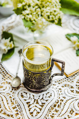 Cup of green tea with jasmine over light back.