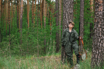 Woman hunter with a gun. Hunting in the woods.
