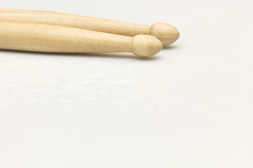 A pair of new wooden drumsticks on a drum patch.