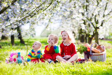 Kids having picnic in blooming garden