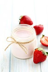 Strawberry yogurt in glass on a blue wooden table