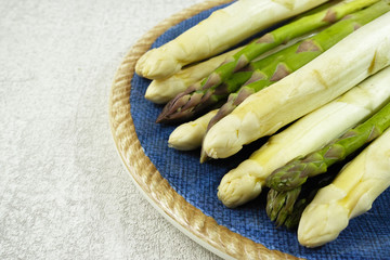 Fresh white and green asparagus on the blue plate