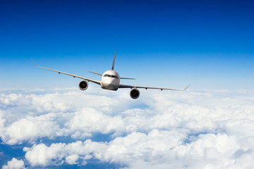 Commercial jet plane flying above clouds