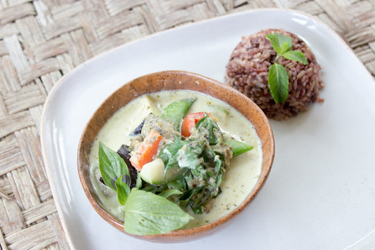 Homemade Green Thai Curry served with brown rice in a bowl and a plate. Originally made in Thailand.