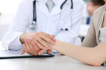 Obraz na płótnie Canvas Hand of doctor reassuring her female patient
