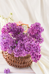 Fototapeta na wymiar Purple lilac flowers on white textile