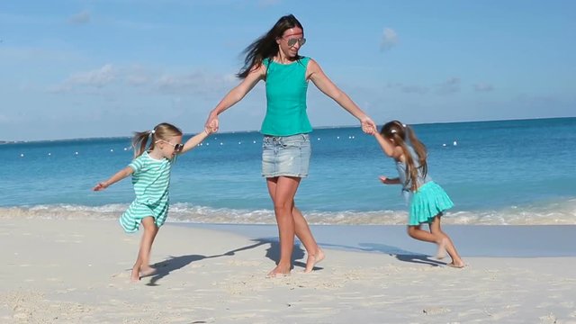 Happy family with little kids having fun at exotic beach on sunny day