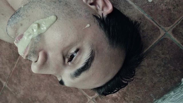 Drunk man with vomit on his face on the floor 