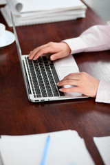 Fototapeta premium Close up of business woman hands typing on laptop computer
