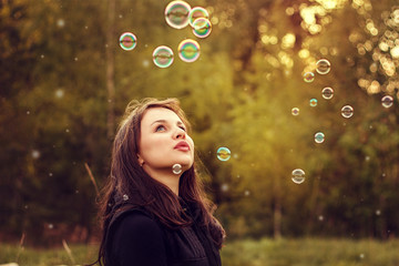 Young girl blowing soap bubbles.