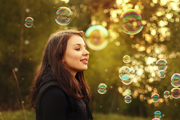 Young girl blowing soap bubbles.