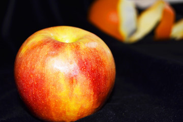apple with orange in the background