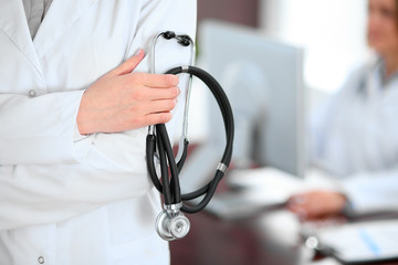 Female doctor standing in a hospital with her colleague in the background