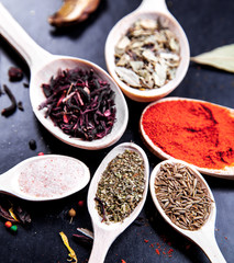 spice in wood spoon on a black background. food