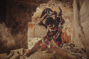 Beautiful woman warrior dressed in steel armor is holding an axe