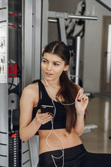 Fototapeta na wymiar Beautiful girl with a phone in the gym