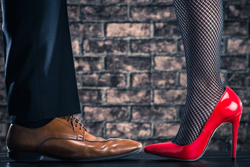 赤いハイヒールを履いている女性と男性の革靴