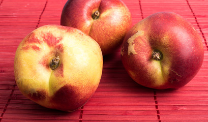 Three apples on red placemat.