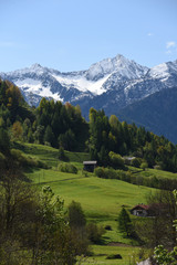 Fototapeta na wymiar paesaggio di montagna estate primavera prateria cime innevate vacanza montagna panorama