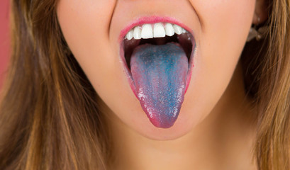 Close up of a woman with open mouth spreading tongue colored in blue with pink background