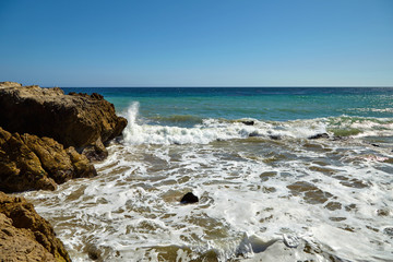 Fototapeta na wymiar Waves beating against coastal rocks on the cliffs