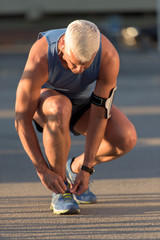Man tying running shoes laces