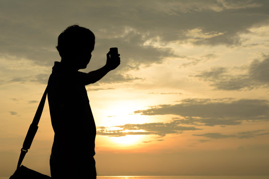 Man silhouette selfie. Background sunset on the sea