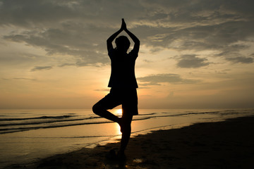 Fototapeta premium Silhouette Woman Yoga.background sunset over the sea.