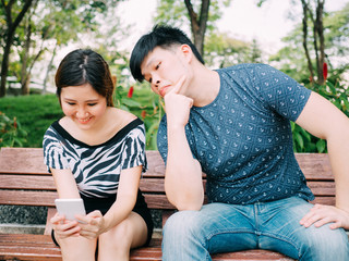 Jealous boyfriend peeking and spying his girlfriend mobile phone