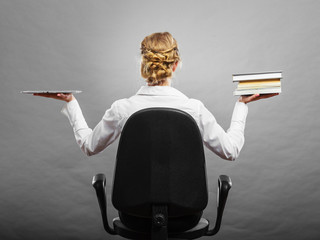 Woman holding traditional book and e-book reader