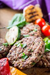 Burgers. Grill burgers. Minced burgers. Roasted burgers with grilled vegetable and herb decoration. Minced meat grilled in a hotel or restaurant.