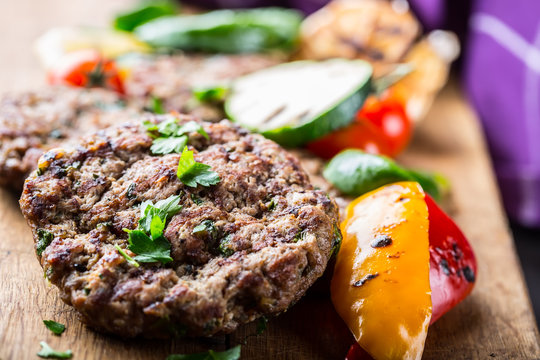 Burgers. Grill burgers. Minced burgers. Roasted burgers with grilled vegetable and herb decoration. Minced meat grilled in a hotel or restaurant.