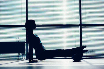 fitness, sport, training and lifestyle concept - woman doing pilates on the floor with foam roller...