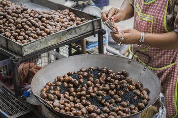 women sell roasted chestnuts to buyers in the market,Sweet chest