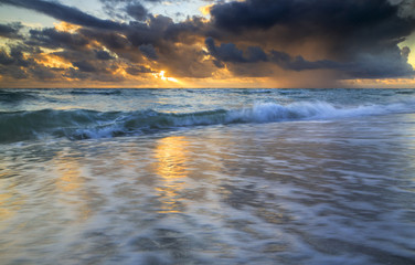 Golden sun rays beaming through the storm clouds over Atlantic a