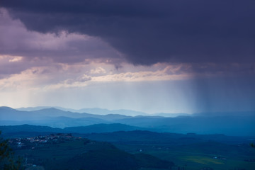 Cloudy rainy sky over mountain valley. Tyscany, Italy