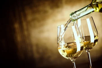 Fotobehang Alcohol Twee glazen witte wijn uit een fles schenken