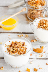 yogurt with homemade granola, nuts and dried fruits in a glass cup