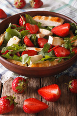 Summer salad with strawberries, grilled chicken, brie and arugula close-up. vertical

