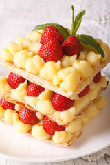 strawberry millefeuille with cream Patissiere close-up on a plate. vertical
