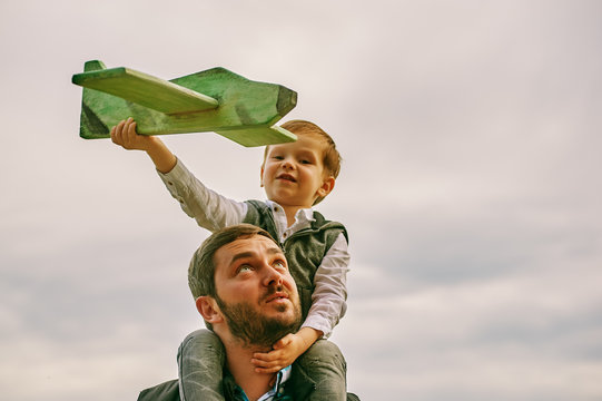 happy father with son playing with toy plane. dream to be a pilot