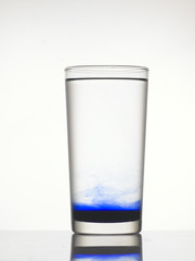 Blue color precipitate at the bottom of the glass.
