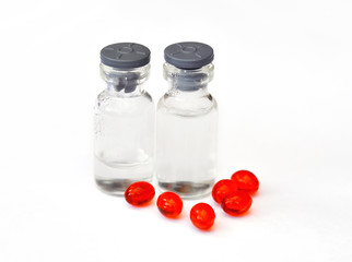 Red pills and vials on white background