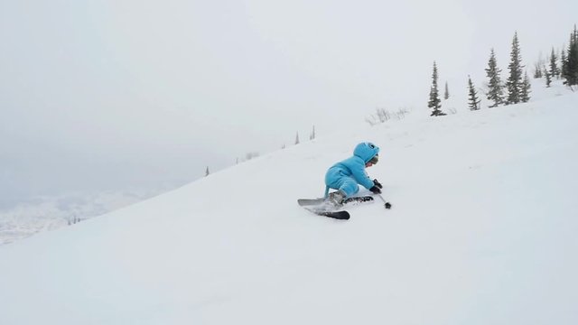 Young boy skiing on mountains and falls down in slowmotion. 1920x1080