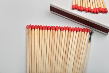 Naklejka premium Many red head matches and one burned put straight in line near a