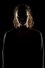 Fototapeta na wymiar portrait of a girl with the face in shadow on a dark background