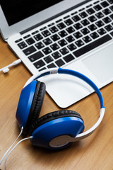 Headphones with laptop on table close up