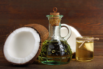 cut the coconut and coconut oil in a small glass jar on a brown wooden background