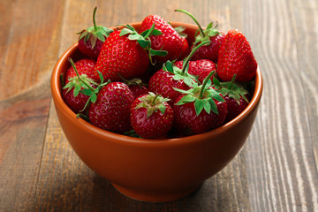 appetizing strawberry in the brown bowl  on brown wooden background