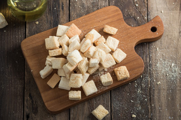 homemade croutons from white bread in wood on old wood table


